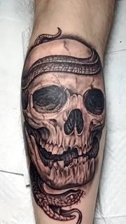 Realism snake skull tattoo by @ade_truemantattoo