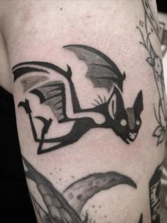 Blackwork flying bat tattoo by @kelpiebat