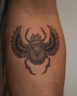 Blackwork winged scarab beetle tattoo by @kwom.tattoos