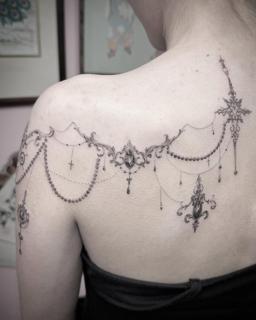 Ornamental ornamental garland tattoo by @chazappletattoo