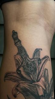 Black and grey dagger lily tattoo by @claretatts