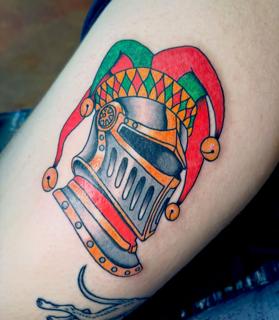 Traditional jester helmet tattoo by @derrythtattoos