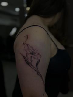 Fine line floral lily tattoo by @dimel_tattooer