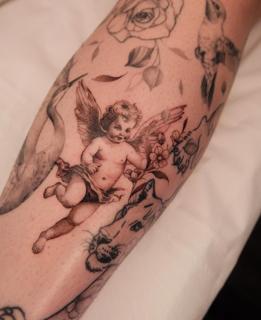 Fine line realism cherub with flowers tattoo by @bethcribbintattoo