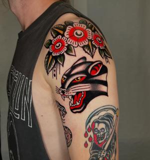 Traditional panther and flowers tattoo by @geeetattoos