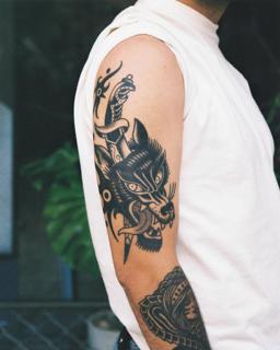 Traditional wolf and dagger tattoo by @geonik.tattoo