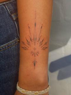 Fine line ornamental burst tattoo by @marcelclaude.tattoo