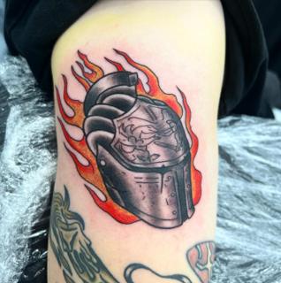 Traditional flaming helmet tattoo by @mikotattoo