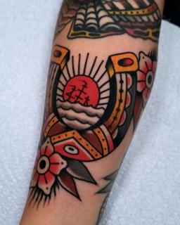 Traditional horseshoe and flower tattoo by @morstattoo