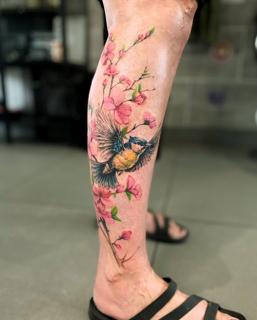 Realism bird and flowers tattoo by @nstia.tatts