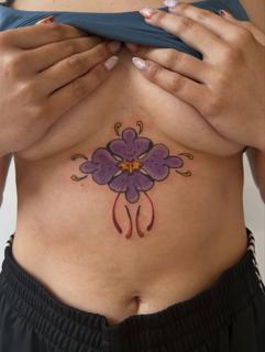 Traditional purple flower tattoo by @buggietattoostudio
