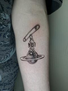 Realism saturn charm tattoo by @polishpollytattoo