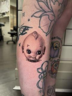 Realism creepy doll head tattoo by @polishpollytattoo