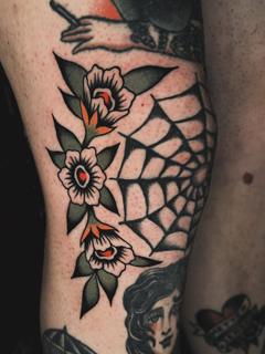 Traditional floral spiderweb tattoo by @siggytattoo
