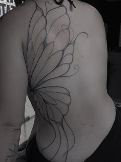 Illustrative blackwork stylized wing tattoo by @yasart.tattoo