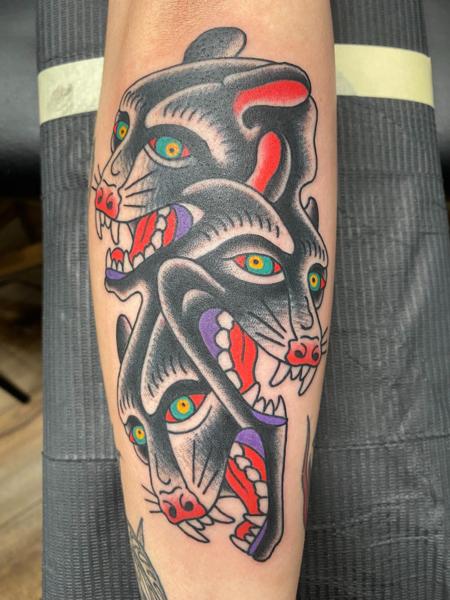 Traditional panther heads tattoo by @a_crockertattoo