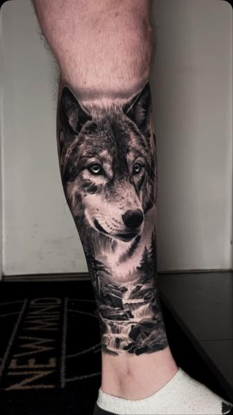 Realism wolf landscape tattoo by @adamblakeytattoos