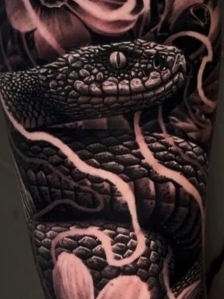 Realism floral snake tattoo by @adamblakeytattoos