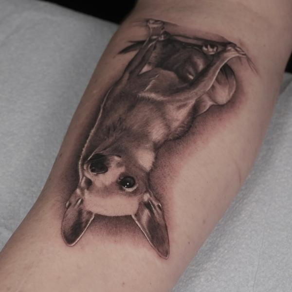 Realism upside down dog tattoo by @adamdeanart