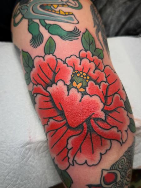 Traditional red flower tattoo by @andrew.bid