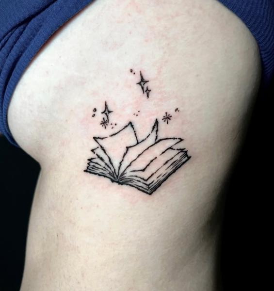 Fine line magical book tattoo by @angie_needs_ink