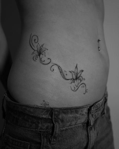 Fine line floral vine tattoo by @kwom.tattoos