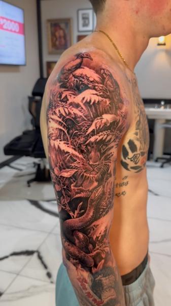 Realism jungle scene tattoo by @carlgracetattoos