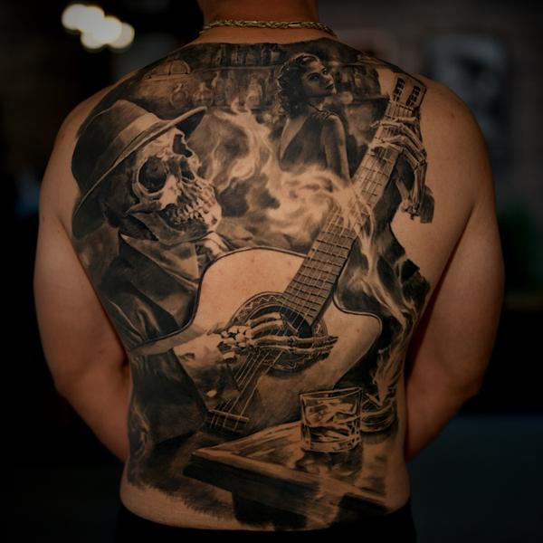 Realism skeleton guitarist tattoo by @carlostorresart