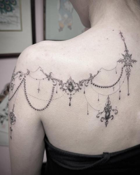 Ornamental ornamental garland tattoo by @chazappletattoo