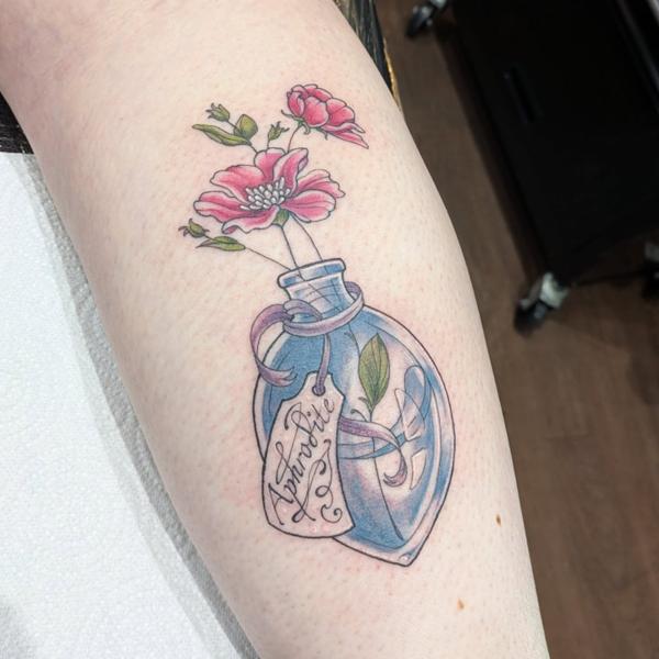 Illustrative floral potion bottle tattoo by @daisy_tattooing