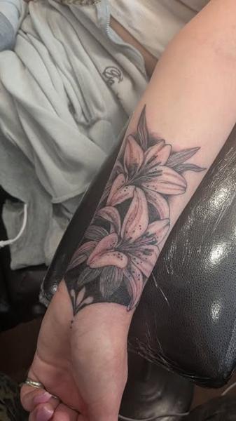 Illustrative black and grey floral lilies tattoo by @daisy_tattooing
