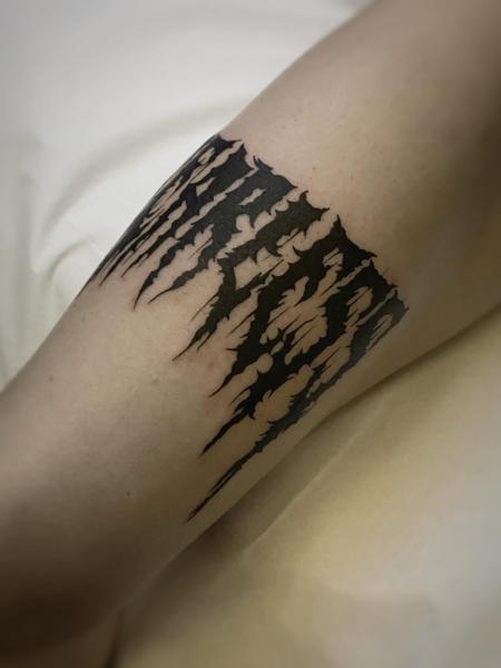 Blackwork dripping text tattoo by @theblackrabbit_tattoostudio