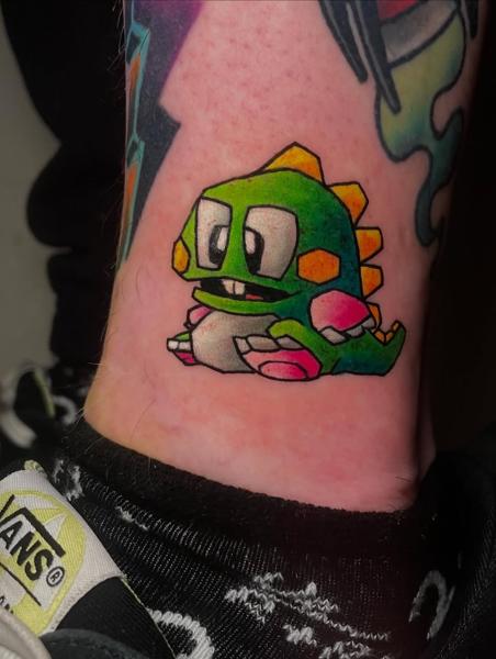 Anime cartoon dinosaur tattoo by @dimos_thrash_tattoo