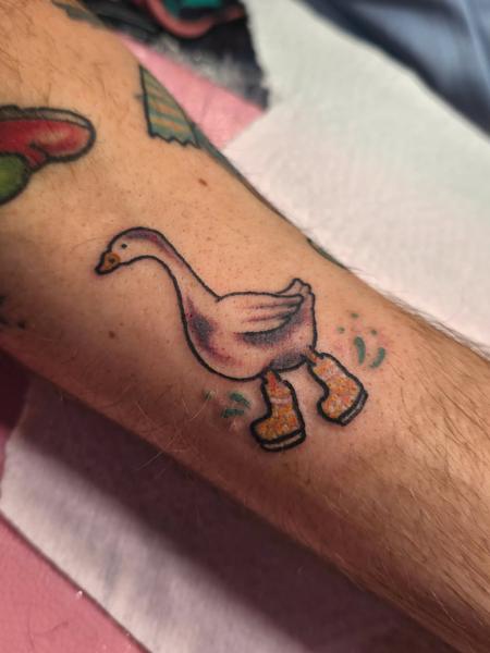 Cartoon traditional goose in boots tattoo by @emmaelizabethtattoo