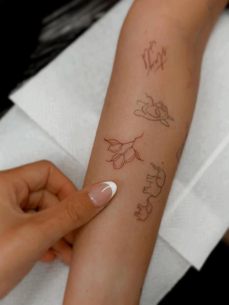 Fine line floral branch tattoo by @emmathornetattoo