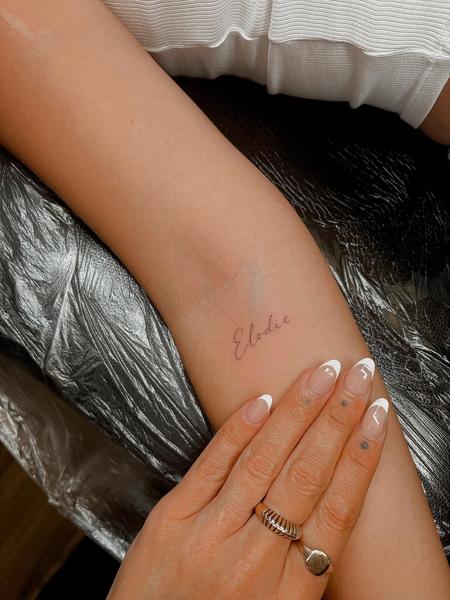 Fine line script name tattoo by @emmathornetattoo