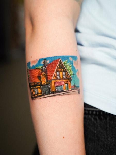 Illustrative color quaint building scene tattoo by @estertarabal