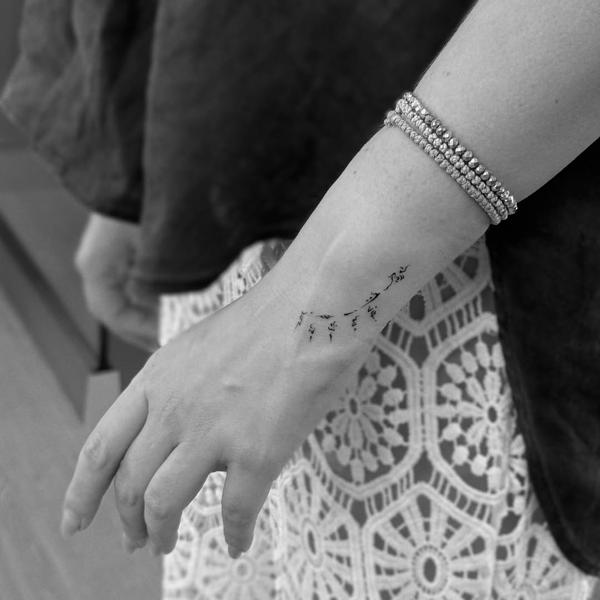 Fine line floral branch tattoo by @eevee.tattoo
