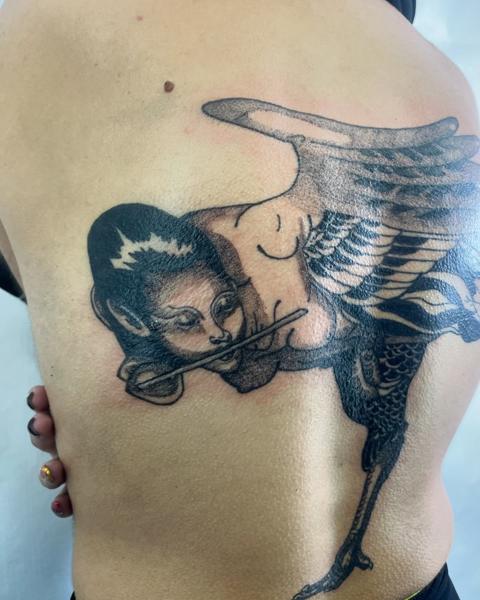 Blackwork winged flutist tattoo by @agave_tattoo