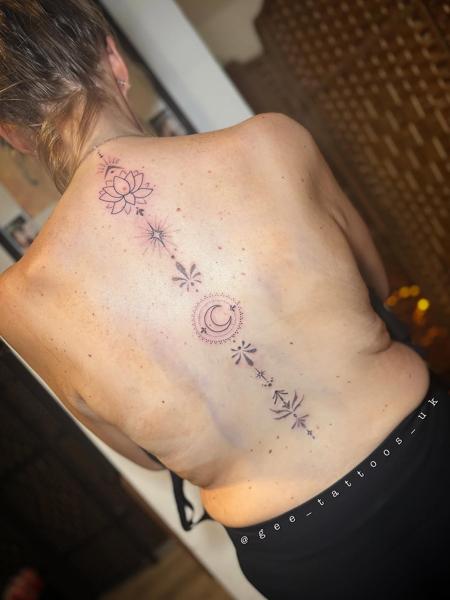 Fine line lotus moon spine tattoo by @gee_tattoos_uk