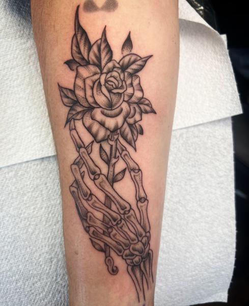 Blackwork skeleton hand rose tattoo by @gnarly_.charlie_