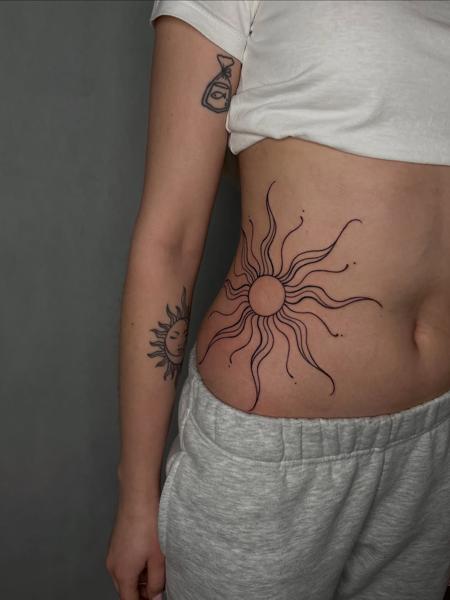 Fine line sun design tattoo by @himiko.ink