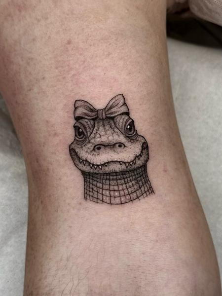 Illustrative crocodile with bow tattoo by @illytattoo