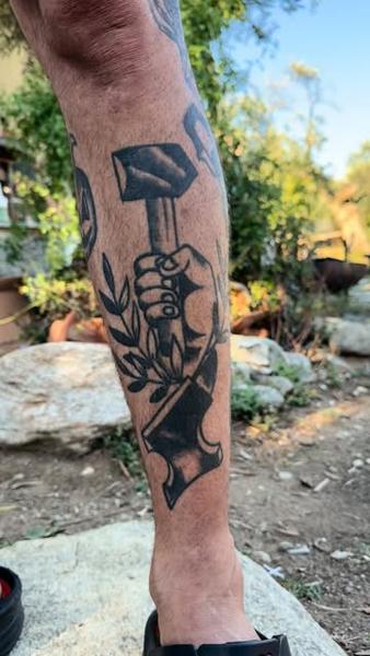 Traditional hand holding hammer tattoo by @il.egall