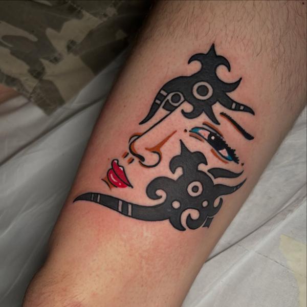 Traditional abstract face tattoo by @ziggi_tattoos