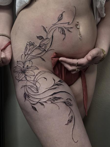 Fine line lily vine tattoo by @steinbach_art