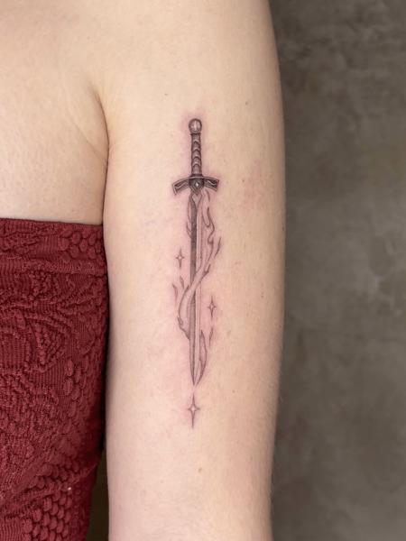 Fine line flaming sword tattoo by @karolina_tattooer