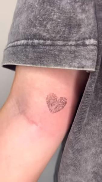 Fine line fingerprint heart tattoo by @nevermind.tattoos