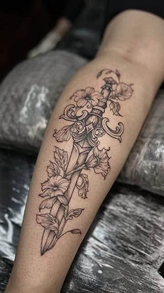 Fine line floral dagger tattoo by @konna.aesthetics