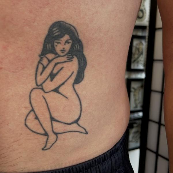Traditional pin-up woman tattoo by @ashestattoo